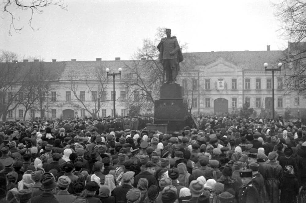 Nuotrauka, kurioje minia žmonių stovi prie paminklo Sovietų Sąjungos generolui