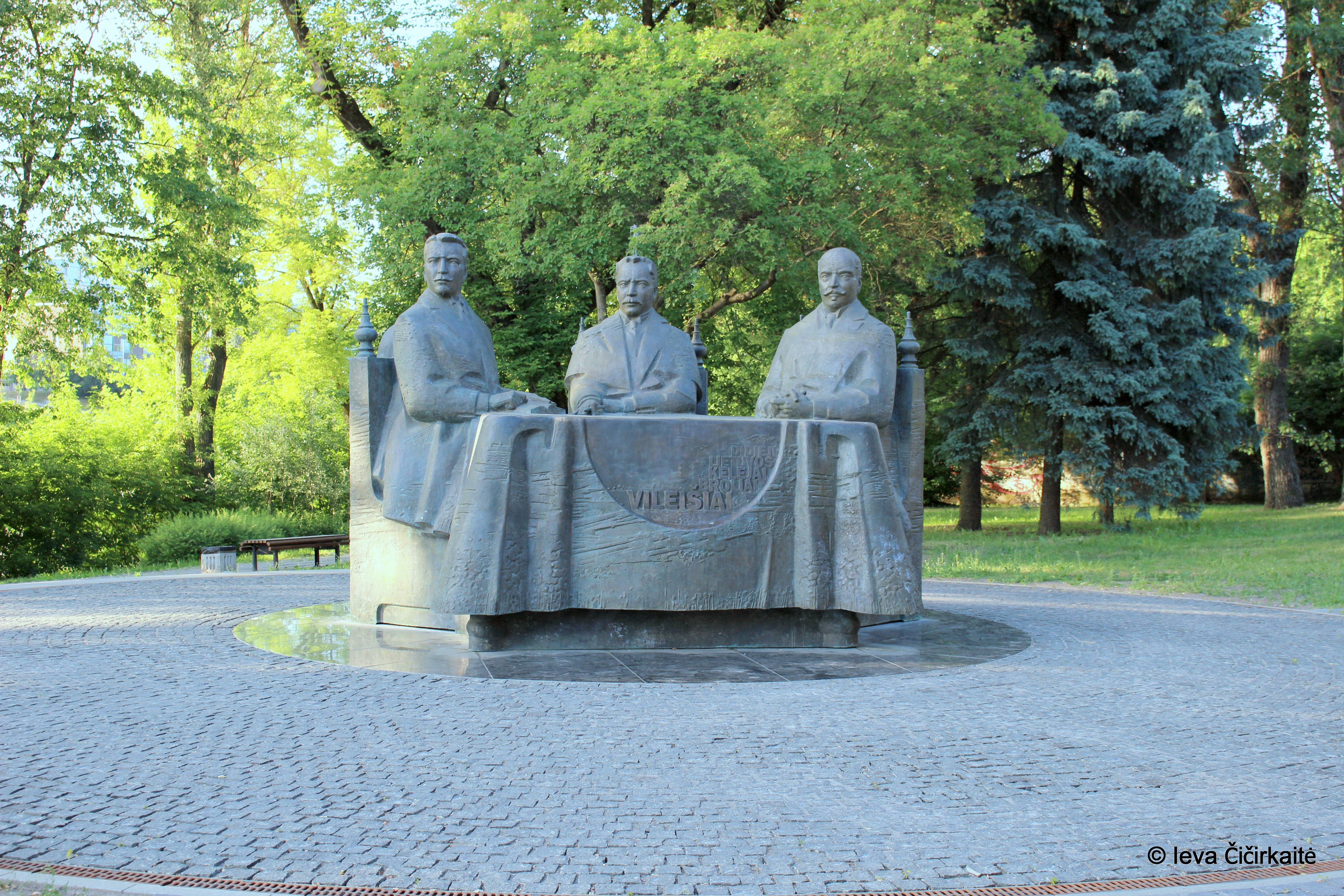 Paminklas broliams Vileišiams Vilniuje. Vaizduojami trijų sėdinčių vyrų figūros. Stalo priekyje išraviruota brolių pavardė - Vileišiai. 